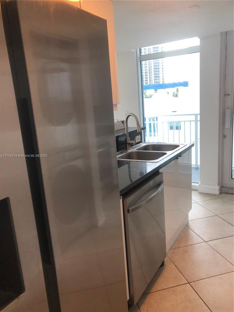 7600 Collins Avenue, Unit 1008 Miami Beach, FL 33141 - Photo 3 of 9 a kitchen with a sink and a refrigerator