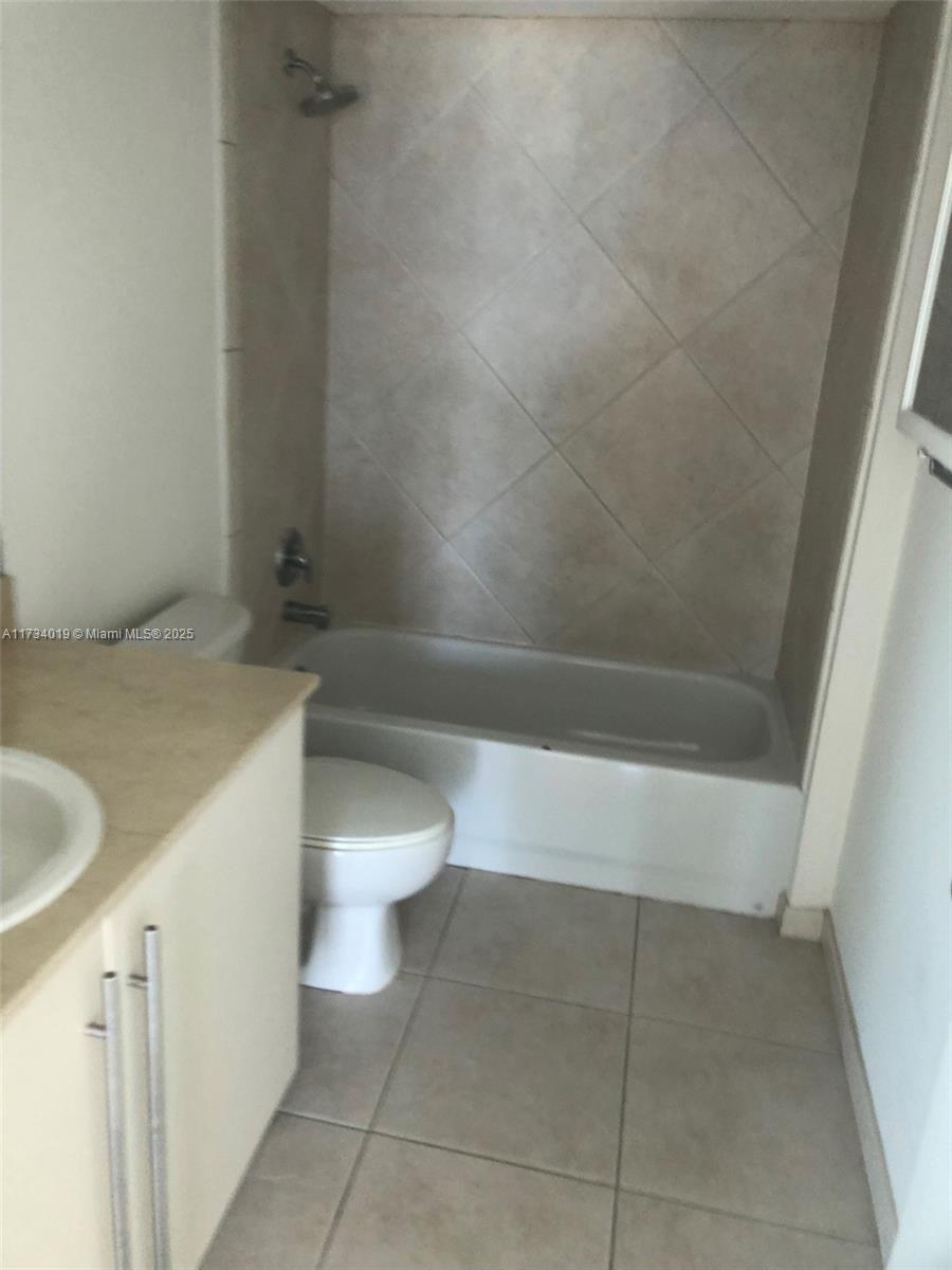 7600 Collins Avenue, Unit 1008 Miami Beach, FL 33141 - Photo 7 of 9 a bathroom with a sink a toilet and shower