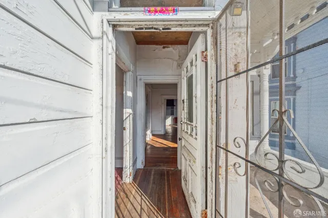 a view of a hallway with wooden floor and staircase