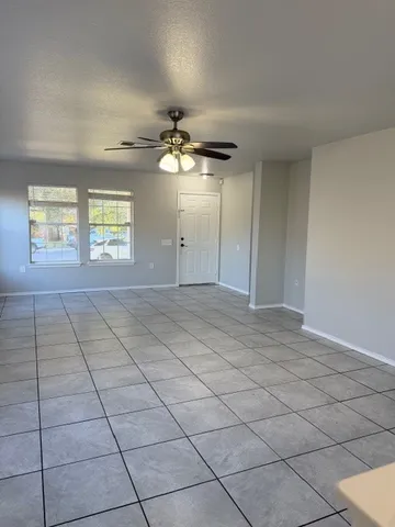 an empty room with windows and fan