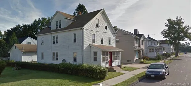 a view of a white building among the yard and patio