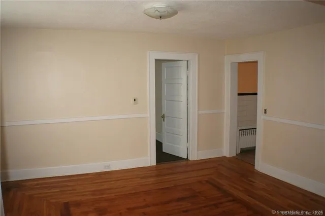 a view of an empty room with wooden floor