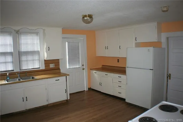 a kitchen with white cabinets and sink