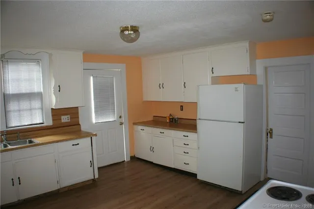 a kitchen with a refrigerator sink stove and cabinets