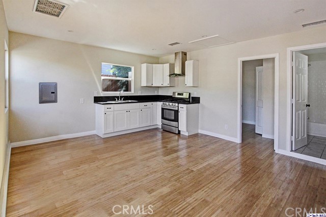 10563 Irma Avenue Tujunga, CA 91042 - Photo 19 of 25 a kitchen with stainless steel appliances granite countertop a stove top oven and sink