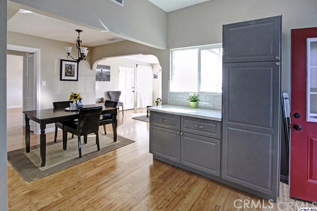 10563 Irma Avenue Tujunga, CA 91042 - Photo 10 of 25 a kitchen with kitchen island granite countertop wooden floors and white cabinets