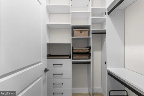 a view of walk in closet with empty racks