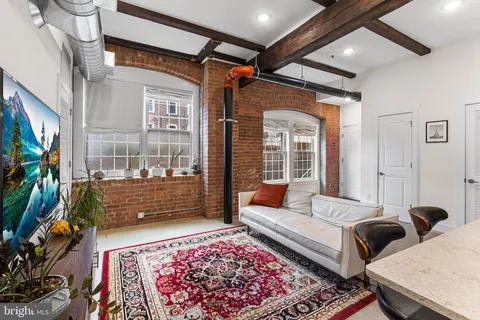 a living room with furniture a rug and a flat screen tv