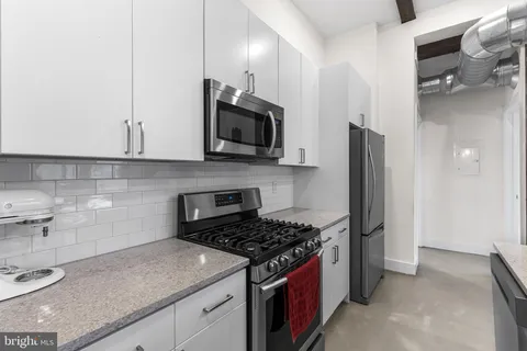 a kitchen with stainless steel appliances granite countertop a stove a refrigerator and a sink