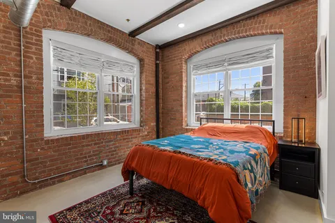 a bed sitting in a bedroom next to a window