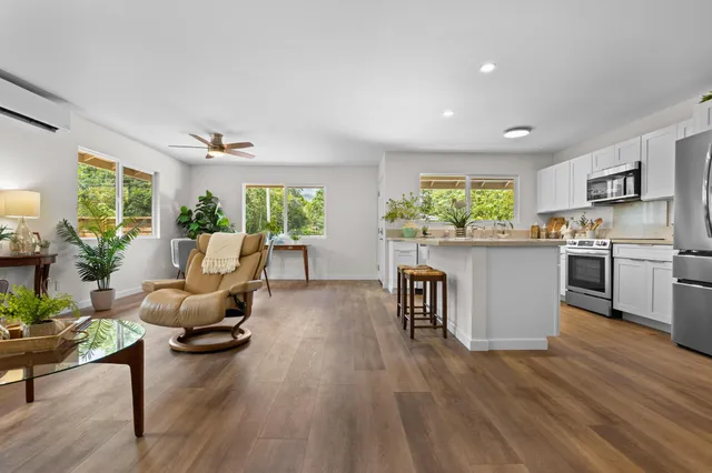 a living room with kitchen island furniture and a wooden floor