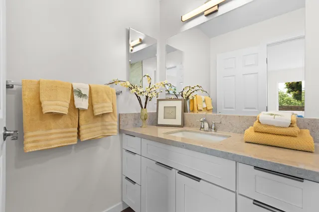a bathroom with a granite countertop sink and a mirror