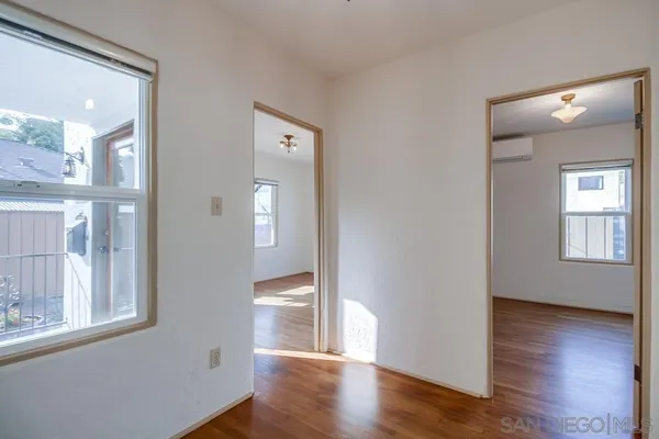 a view of an empty room with wooden floor and closet