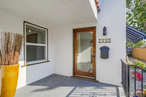 a view of a hallway with wooden floor and a bathroom