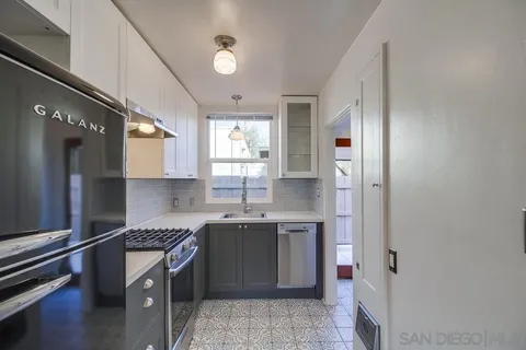 a view of backyard with wooden fence and large trees