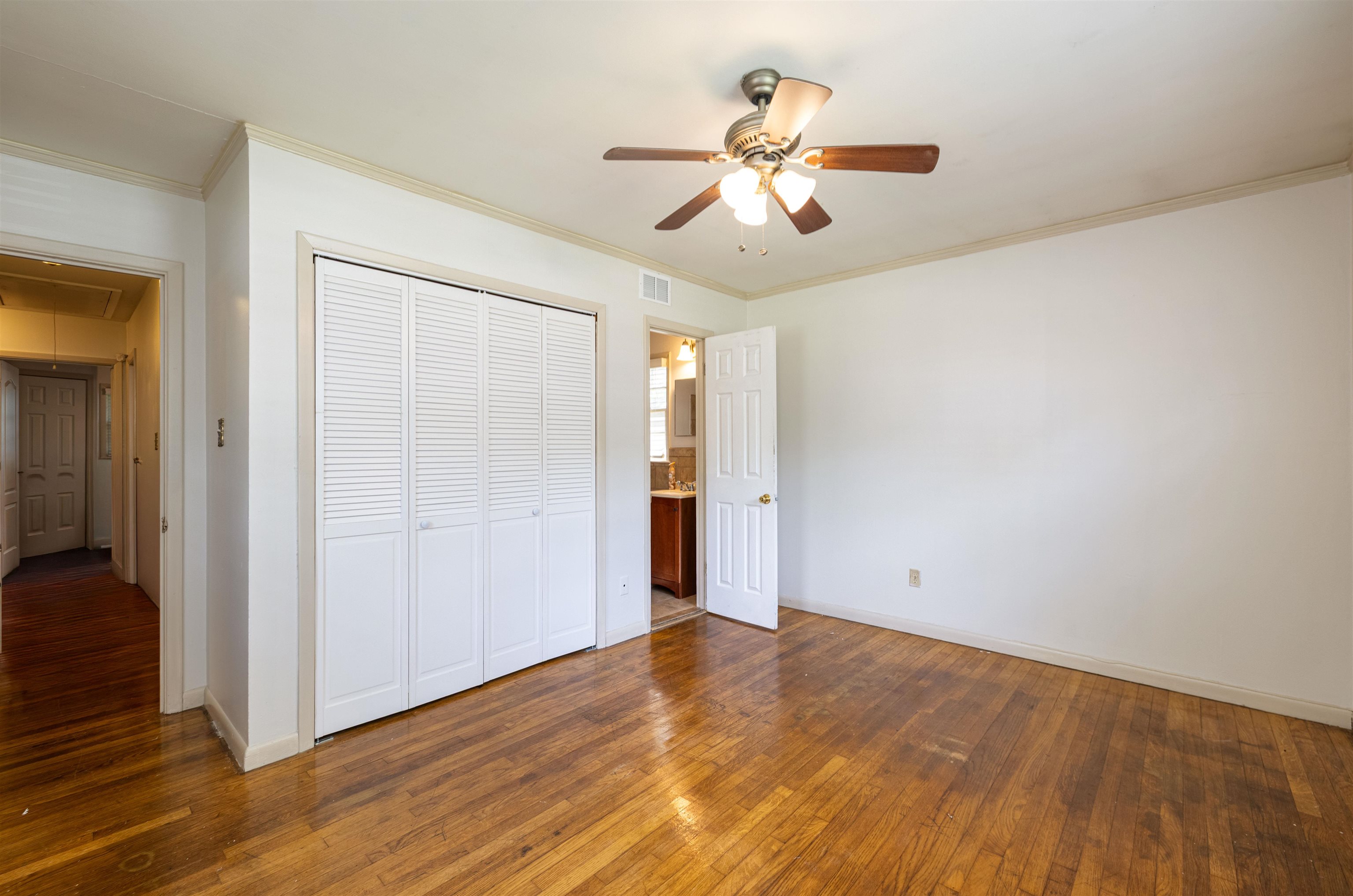 3953 Comanche Road Memphis, TN 38118 - Photo 19 of 24 Unfurnished bedroom with attic access, hardwood / wood-style flooring, ornamental molding, a closet, and ceiling fan