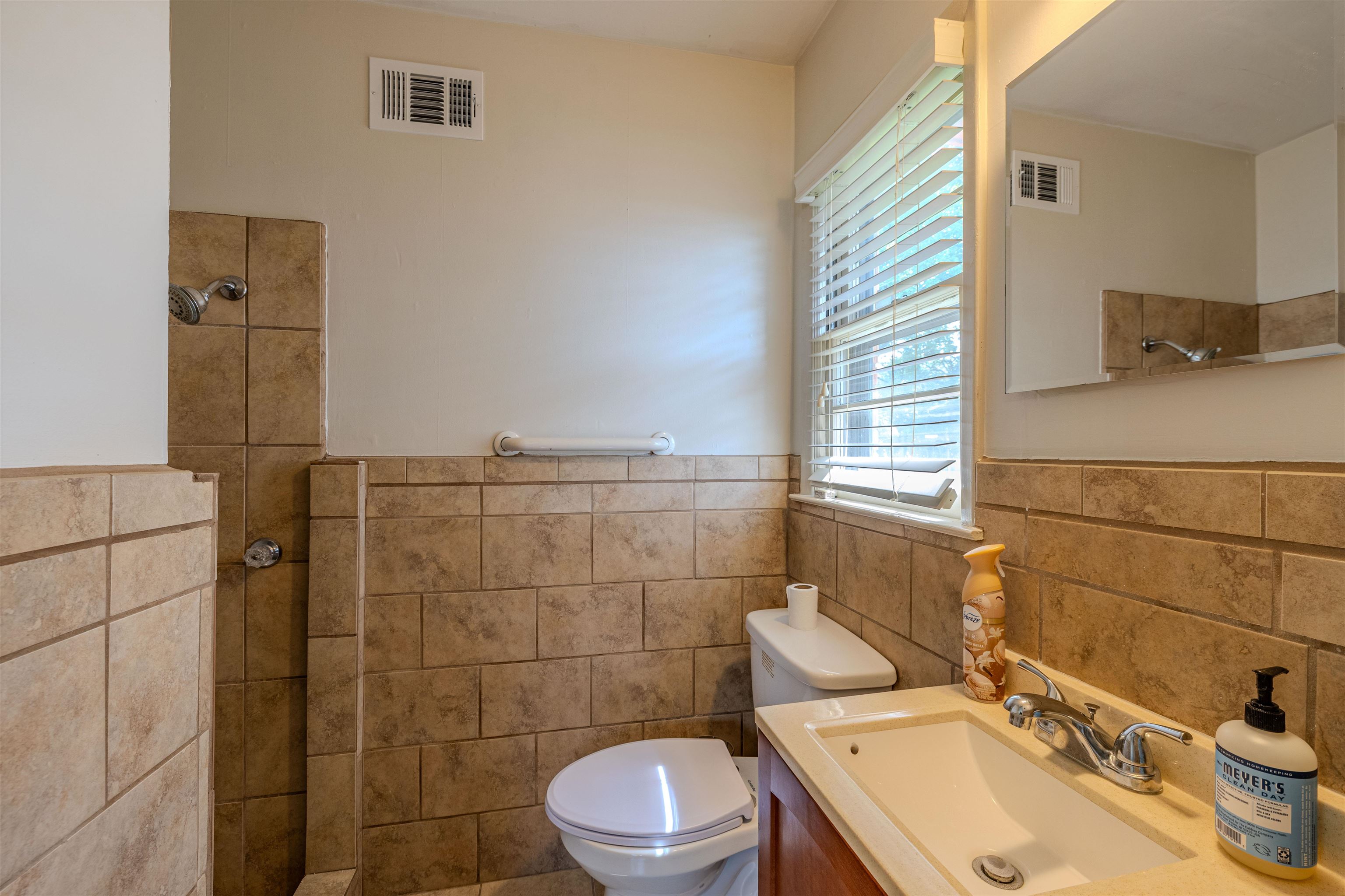 3953 Comanche Road Memphis, TN 38118 - Photo 20 of 24 Bathroom with tile walls, a walk in shower, vanity, and a wainscoted wall