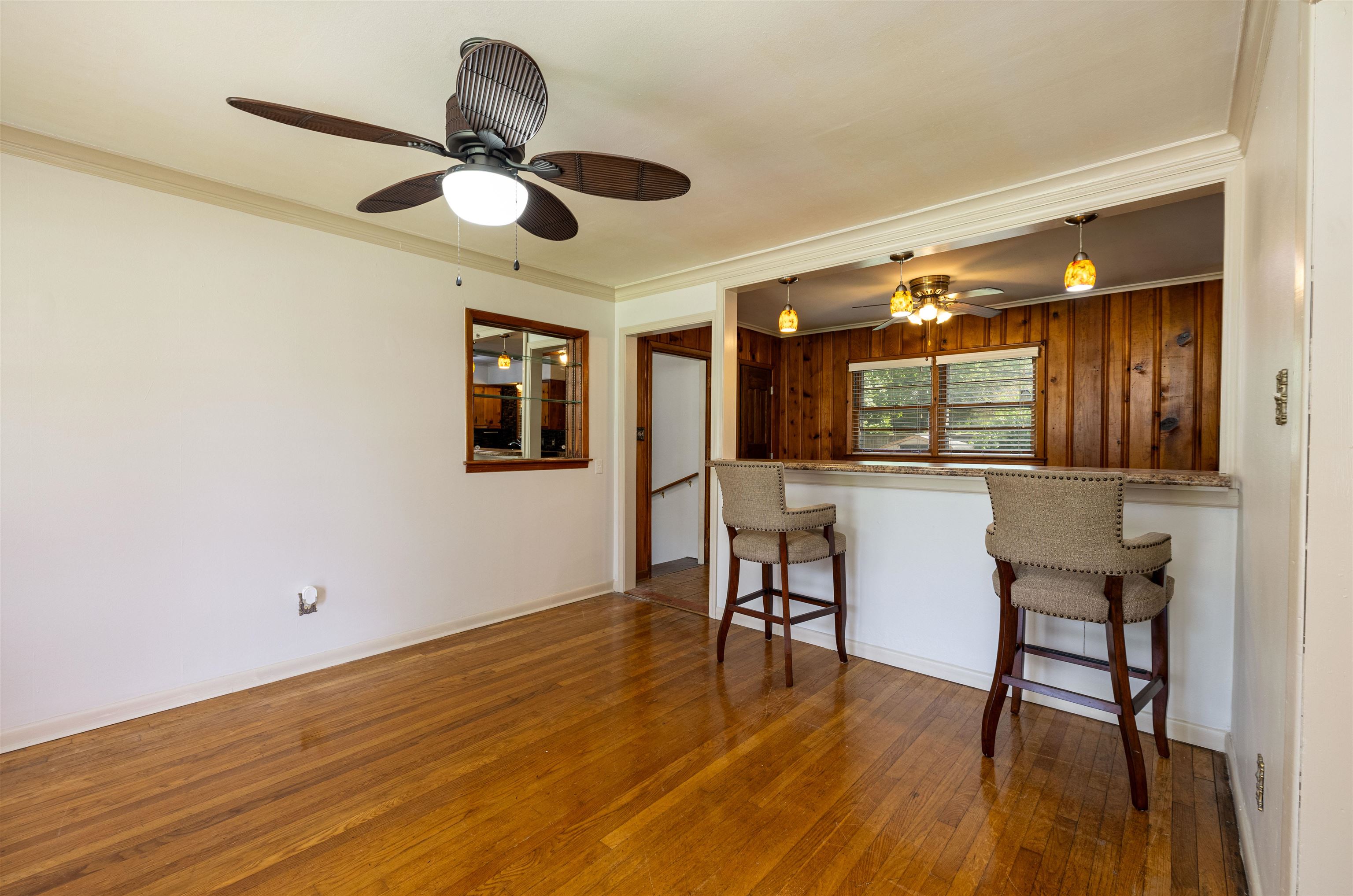 3953 Comanche Road Memphis, TN 38118 - Photo 21 of 24 Kitchen featuring a ceiling fan, wood-type flooring, a kitchen breakfast bar, crown molding, and pendant lighting