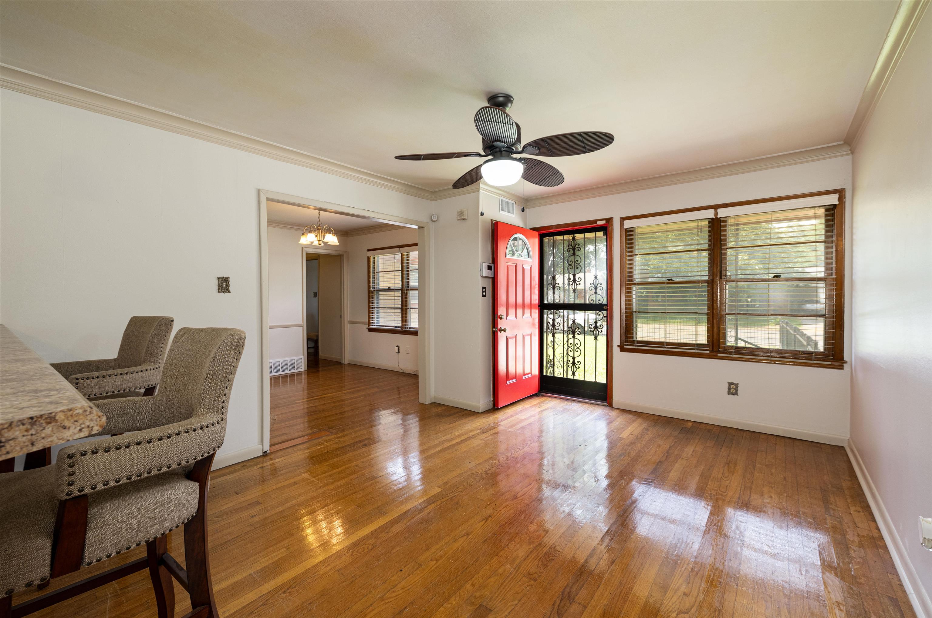 3953 Comanche Road Memphis, TN 38118 - Photo 9 of 24 Spare room with a chandelier, ornamental molding, light wood-style flooring, and a ceiling fan