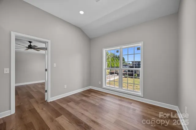 an empty room with wooden floor and a window