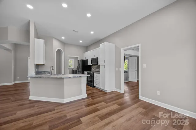 a view of kitchen with stainless steel appliances refrigerator stove microwave and cabinets
