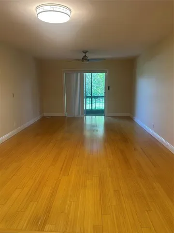 a view of empty room with a kitchen