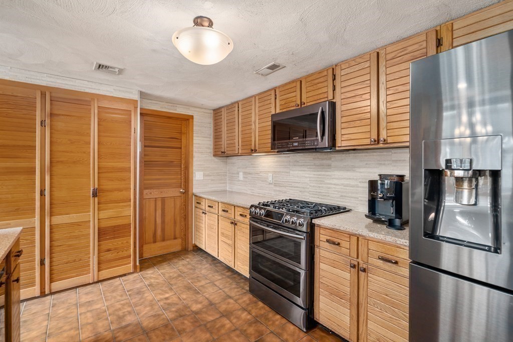 6 Crestwood Road North Reading, MA 01864 - Photo 7 of 36 a kitchen with stainless steel appliances granite countertop a stove sink microwave and refrigerator