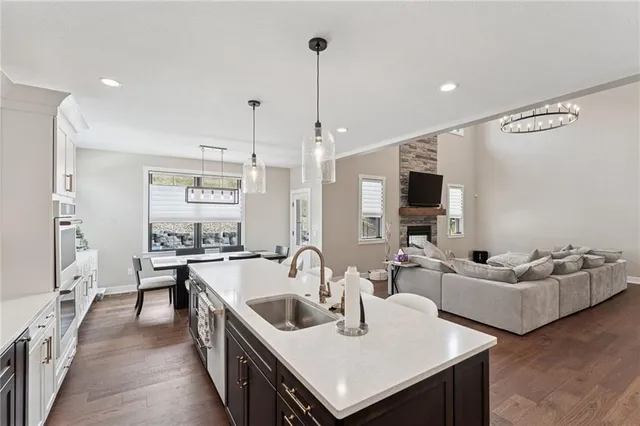 a kitchen with sink refrigerator and couches