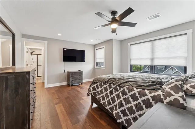 a bedroom with a bed a flat screen tv and a large window
