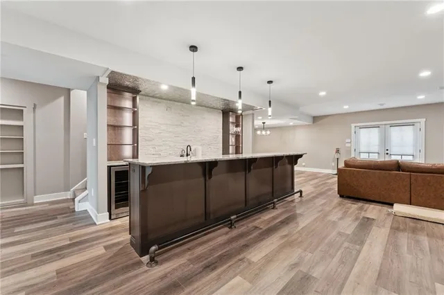 a view of a kitchen with kitchen island a counter top space a sink and stainless steel appliances
