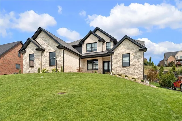 a front view of a house with a garden and yard
