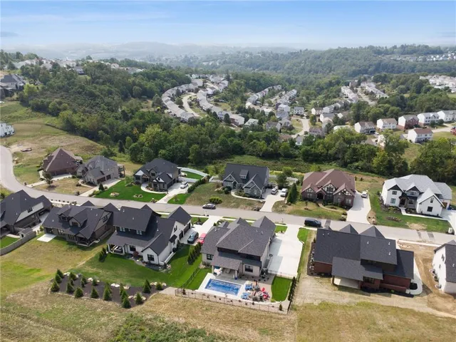 an aerial view of a houses with a swimming pool