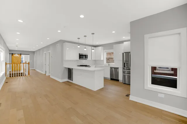 a large white kitchen with stainless steel appliances