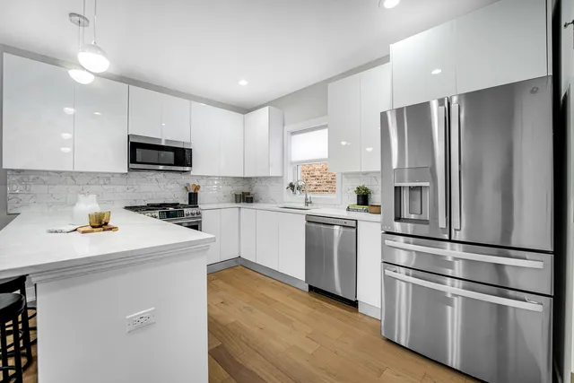 a kitchen with white cabinets and stainless steel appliances