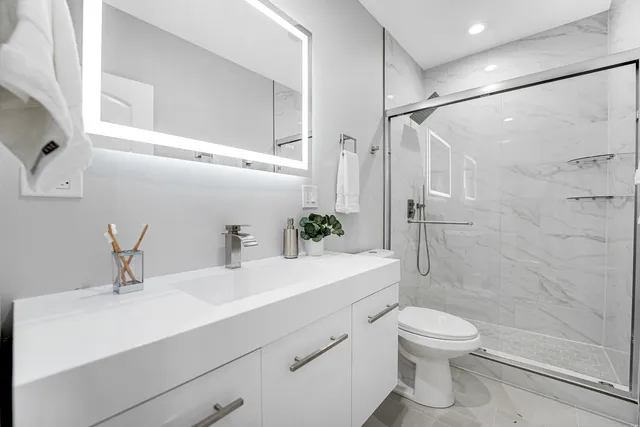 a bathroom with a sink a toilet and shower