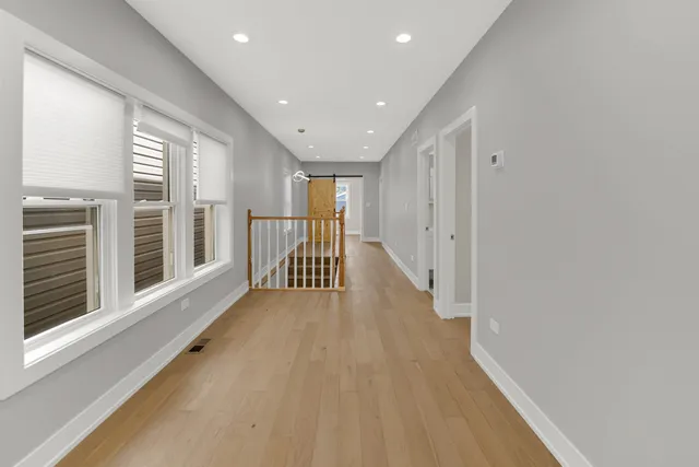 a view of a hallway with wooden floor