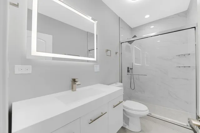 a bathroom with a sink a toilet and shower