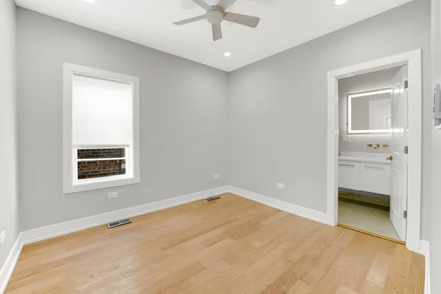 an empty room with a window and a ceiling fan