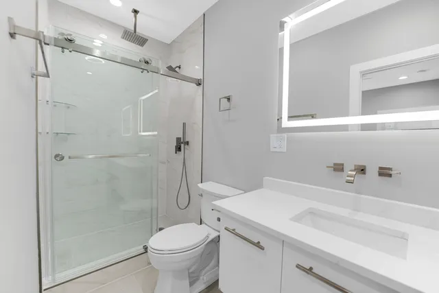 a bathroom with a sink a toilet and shower