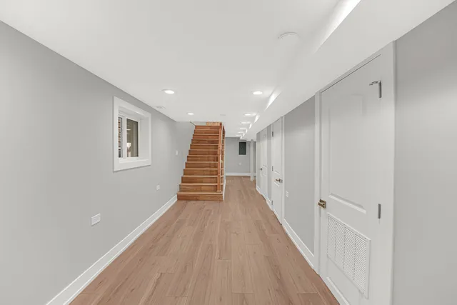 a view of a hallway with wooden floor and staircase