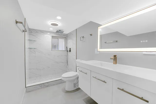 a spacious bathroom with a shower sink vanity mirror and toilet