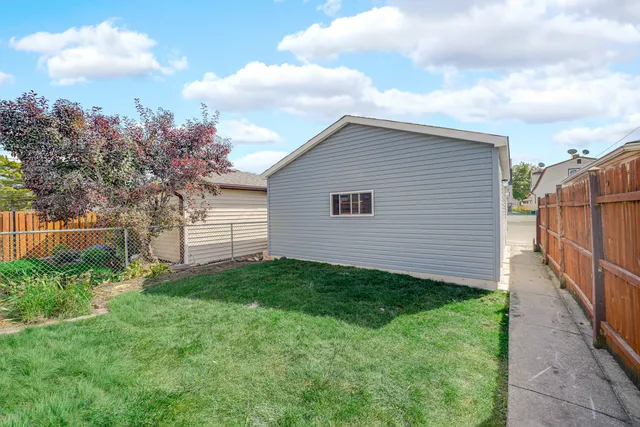 a view of a backyard with potted plants and wooden fence