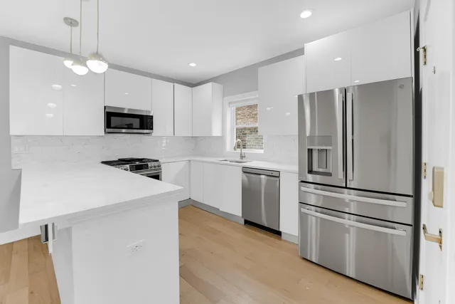 a kitchen with stainless steel appliances a refrigerator sink and microwave