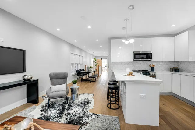 a living room with furniture a flat screen tv and kitchen view