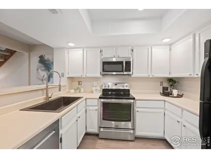 a kitchen with a sink stove and white cabinets