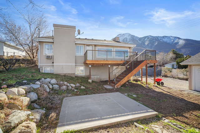 4426 South 3035 East Holladay, UT 84124 - Photo 36 of 49 Back of house featuring stairs, a deck with mountain view, a chimney, and a patio area