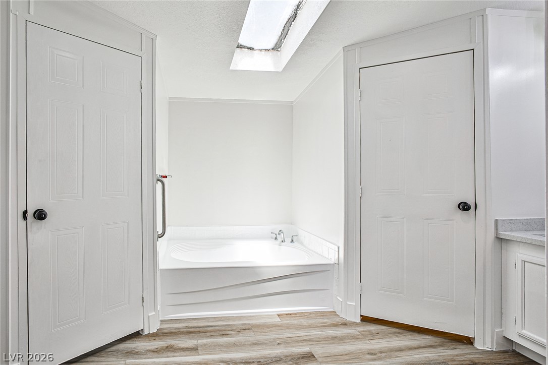 273 Aztec Lane Henderson, NV 89015 - Photo 19 of 28 Indulge in relaxation with this serene bathroom, featuring a deep soaking tub beneath a skylight.
