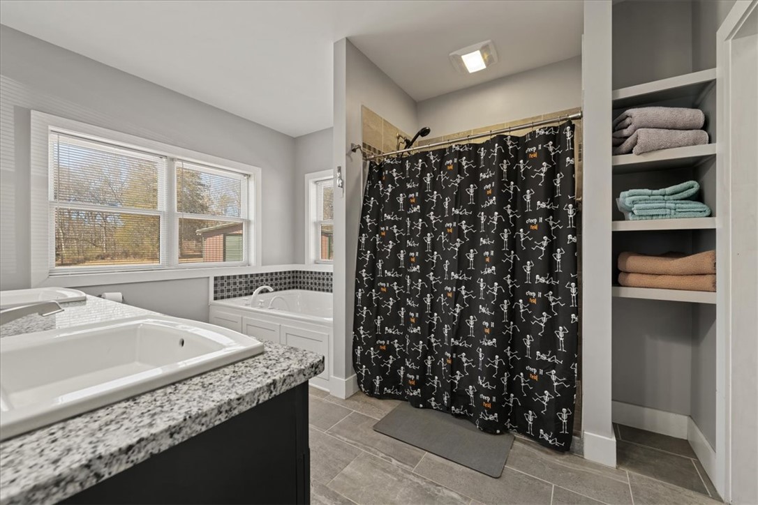 212 Winding Lane Seneca, SC 29672 - Photo 15 of 48 This primary bathroom features sleek countertops, a built-in tub, and ample storage for a serene retreat.