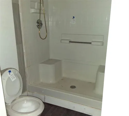 a bathroom with a shower a toilet and a shower