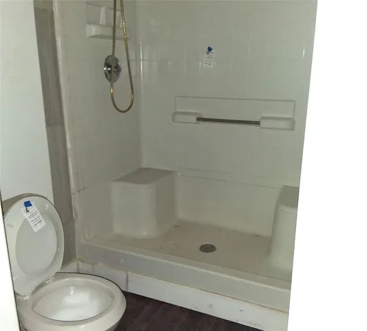 a bathroom with a shower a toilet and a shower